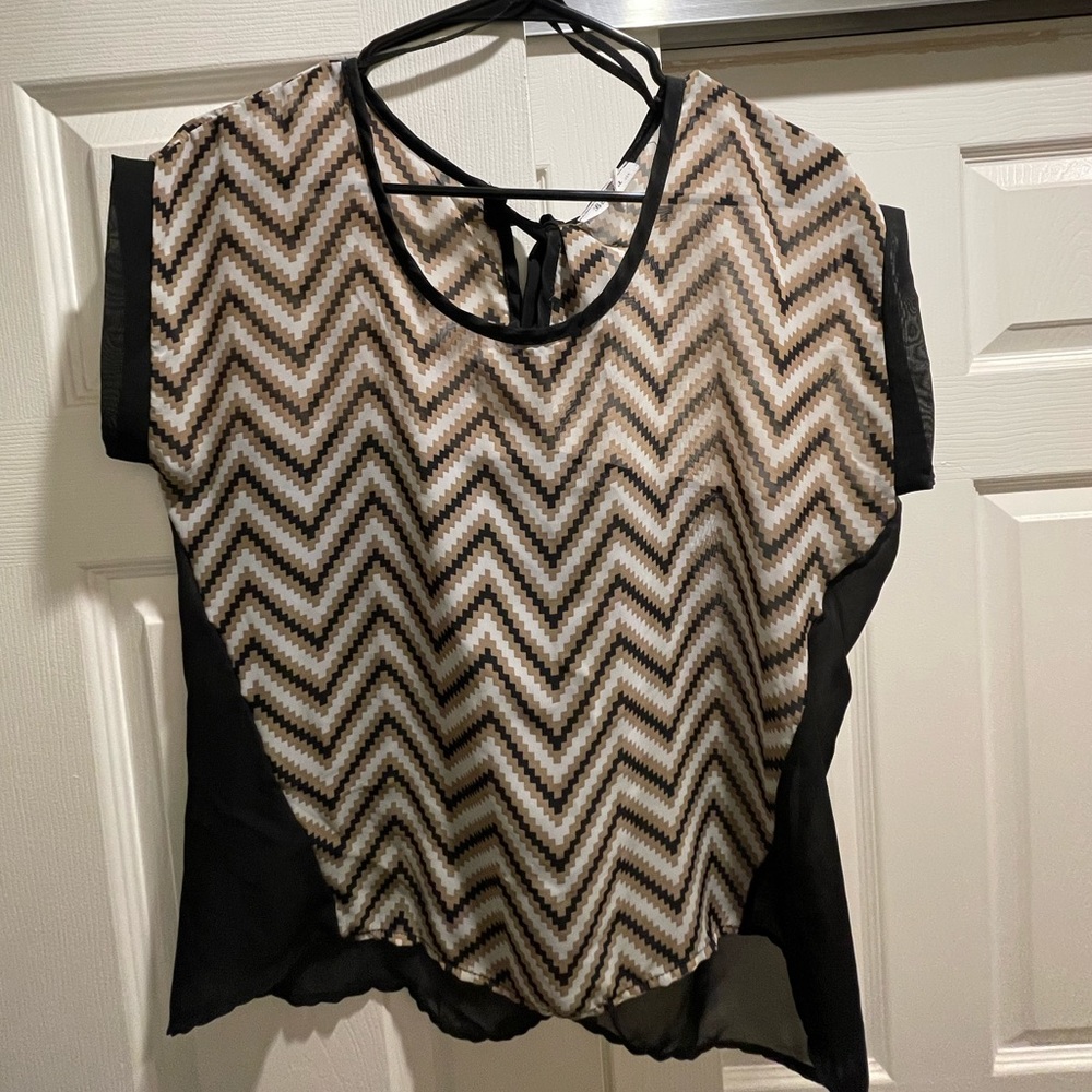 Tan, black + white patterned blouse with tie in the back. Size medium